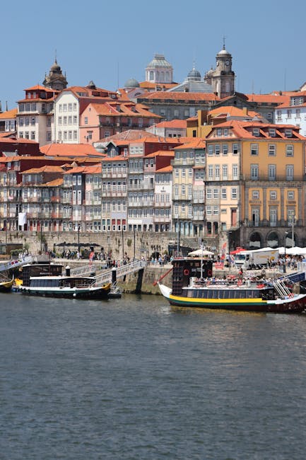 Vibrant image of Porto's riverfront with classic colorful architecture and moored boats.